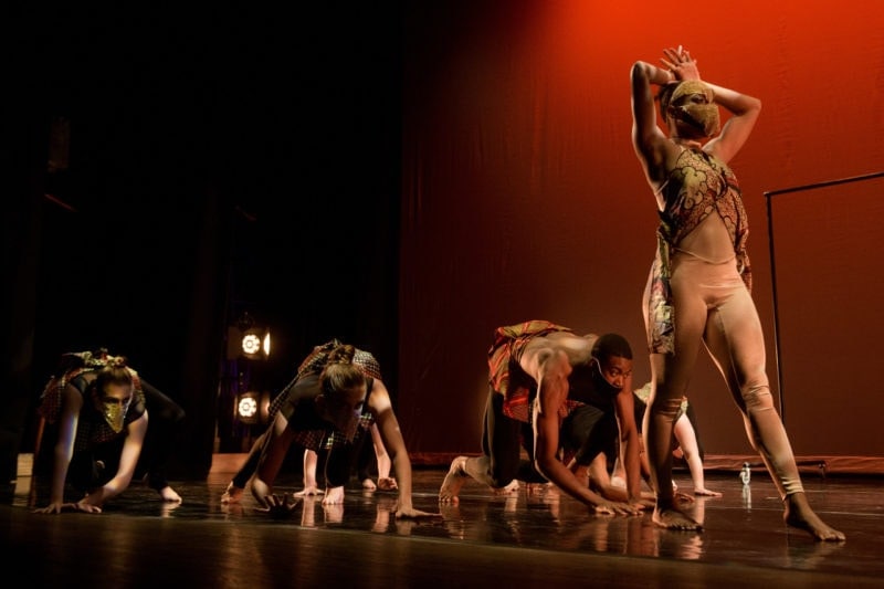 Three dancers on all fours, and one dancer standing
