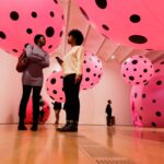 Students standing under giant pink balls