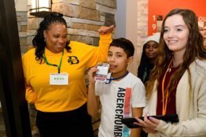 Two Brenau faculty and staff with middle school students