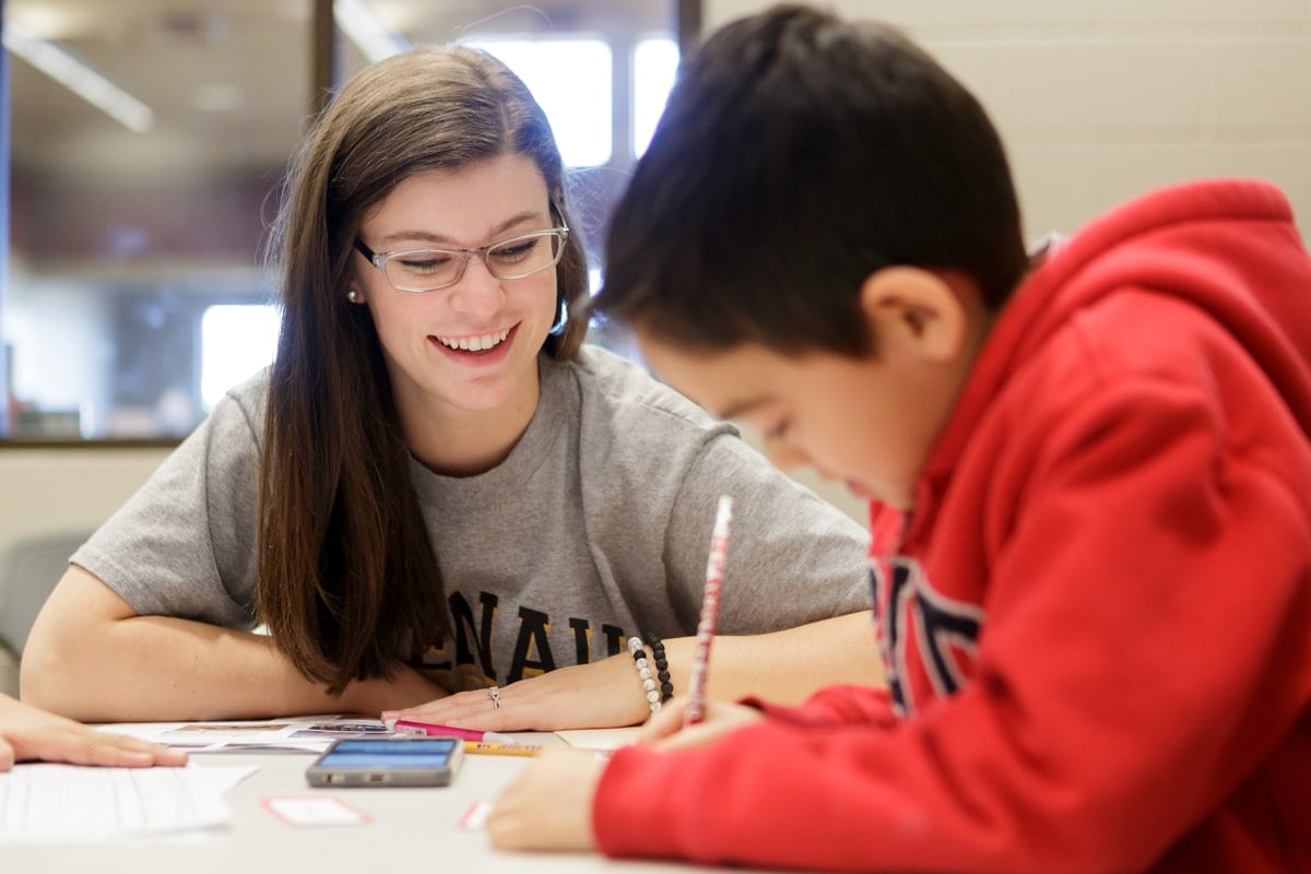 Cady Brown, a junior early childhood education major, works with a student on his story for 