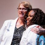 Faculty member hugging nursing student