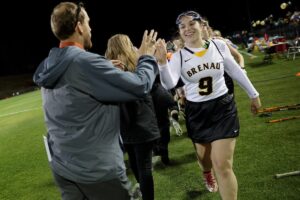 Brenau's Allie McConnell, a junior from Cumming, Ga., high fives Georgetown's coach after the first Brenau lacrosse match against Georgetown College on Friday, Feb. 9, 2018 in Gainesville, Ga. (AJ Reynolds/Brenau University)