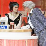 old woman looking at younger woman behind a counter