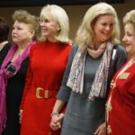 Dina Hewett, second from right, and Sandra Greniewicki share a moment as registered nurses are invited to the stage for the blessing of the hands during Masters in the Art of Nursing: Healers among us on Thursday, Feb. 15, 2018 at Whalen Auditorium in Brenau East in Featherbone Communiversity in Gainesville. (AJ Reynolds/Brenau University)