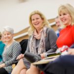 Dina Hewett, center, smiles as she is introduced as one of the honorees during Masters in the Art of Nursing: Healers among us on Thursday, Feb. 15, 2018 at Whalen Auditorium in Brenau East in Featherbone Communiversity in Gainesville. (AJ Reynolds/Brenau University)