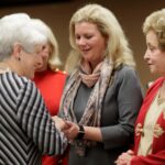 Dina Hewett, right, reacts as she gets a hug while receiving her award from Sandra Greniewicki during Masters in the Art of Nursing: Healers among us on Thursday, Feb. 15, 2018 at Whalen Auditorium in Brenau East in Featherbone Communiversity in Gainesville.