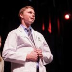 PA student buttons his white coat
