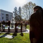 Brenau students stand in silence around the Grace Hooten Moore Memorial Fountain and read the names of each victim after a bell rang from Grace Episcopal Church in memory. (AJ Reynolds/Brenau University)