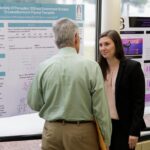 Laura Carter talks with Bob Cantu during the symposium.