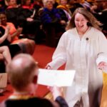 Sommer Stockton runs to receive the Massey Journalism Scholarship from Kevin Mace during the Brenau University Honors Convocation on Thursday, April 12, 2018. (AJ Reynolds/Brenau University)