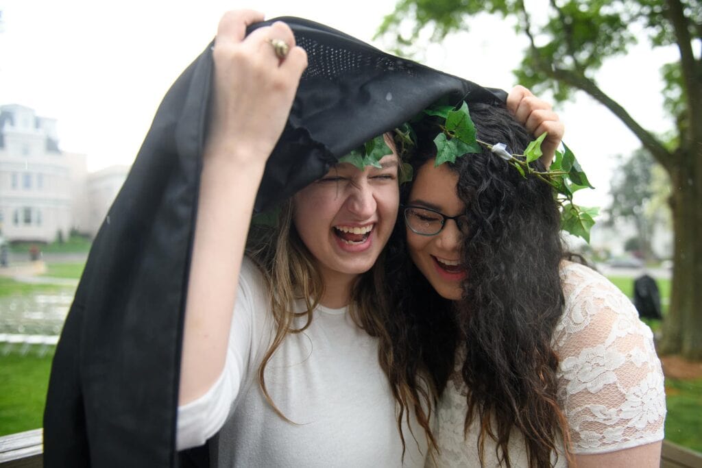 Students hide from rain.