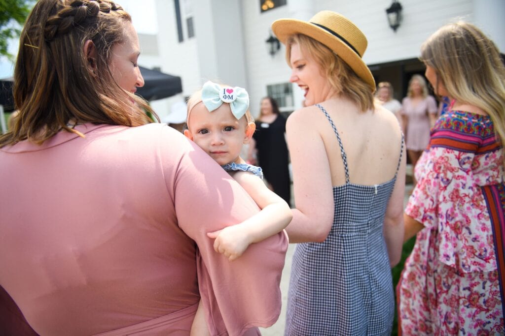 An alum holds her daughter.