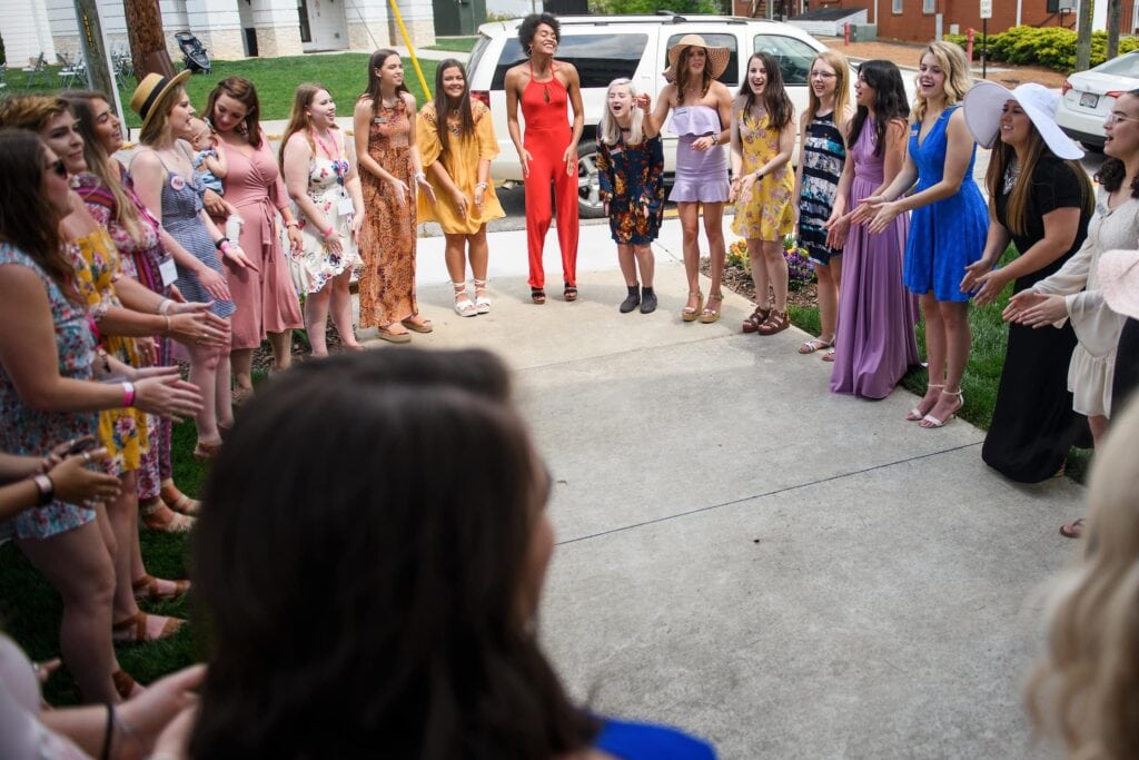 A group of women stand in a circle.