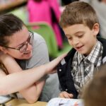 A college student and elementary school student read to each other. 3