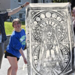 Participants in the Spring Showcase of the Arts show off their large print of a goddess
