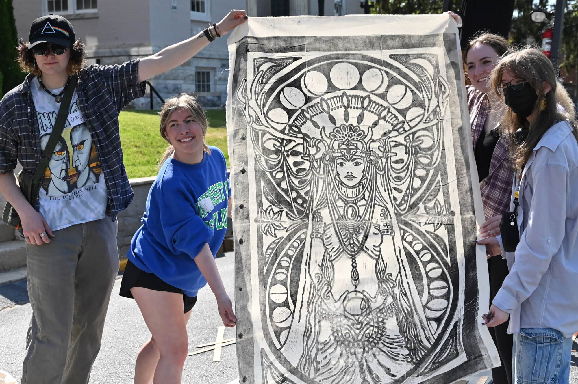Participants in the Spring Showcase of the Arts show off their large print of a goddess