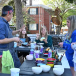 Studio arts program director Huy Chu assists participants with pottery glazing.