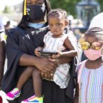 A graduate in regalia with her children