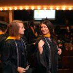 Brenau University students Sara Higgins, left, and Ivie Hall get ready for the graduate and undergraduate commencement Saturday May 5, 2018 in Gainesville, Ga. (Jason Getz for Brenau University)