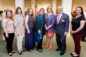 From left to right: Brenau Assistant Gallery Director Allison Lauricella, Erin McIntosh, Rachel Landers Sisk, Sara Oakley, Lyndrid Patterson, Brenau President Ed Schrader and Brenau Gallery Director Nichole Rawlings pose for a photo during the President's Summer Art Series reception on June 7 in the Sellers Gallery. (AJ Reynolds/Brenau University)