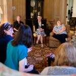 Brenau President sitting in the tea room with faculty