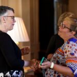 woman shrugs shoulders while talking with the president