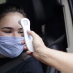 Paris Aguilar, a first year student, has her temperature taken as part of a health screening during drive thru check in. (AJ Reynolds/Brenau University)
