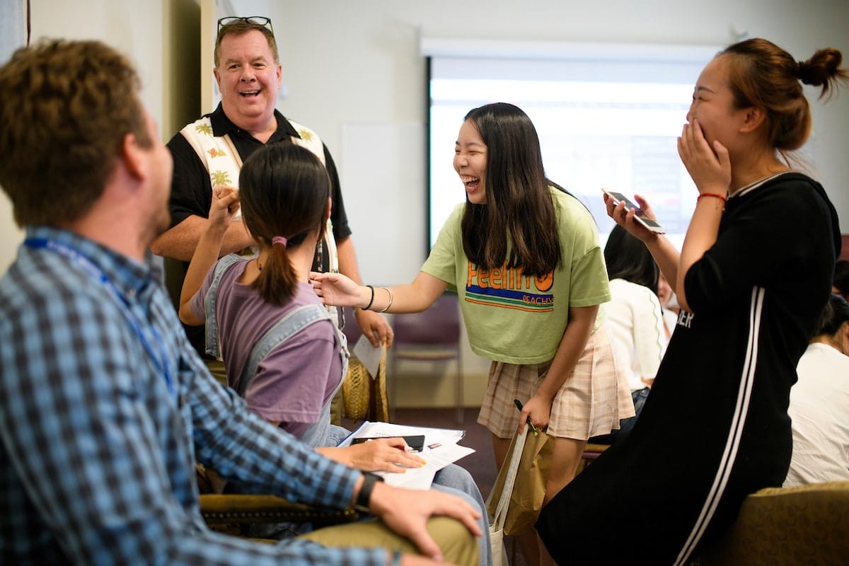 Brenau faculty and students from China laugh while work on a project