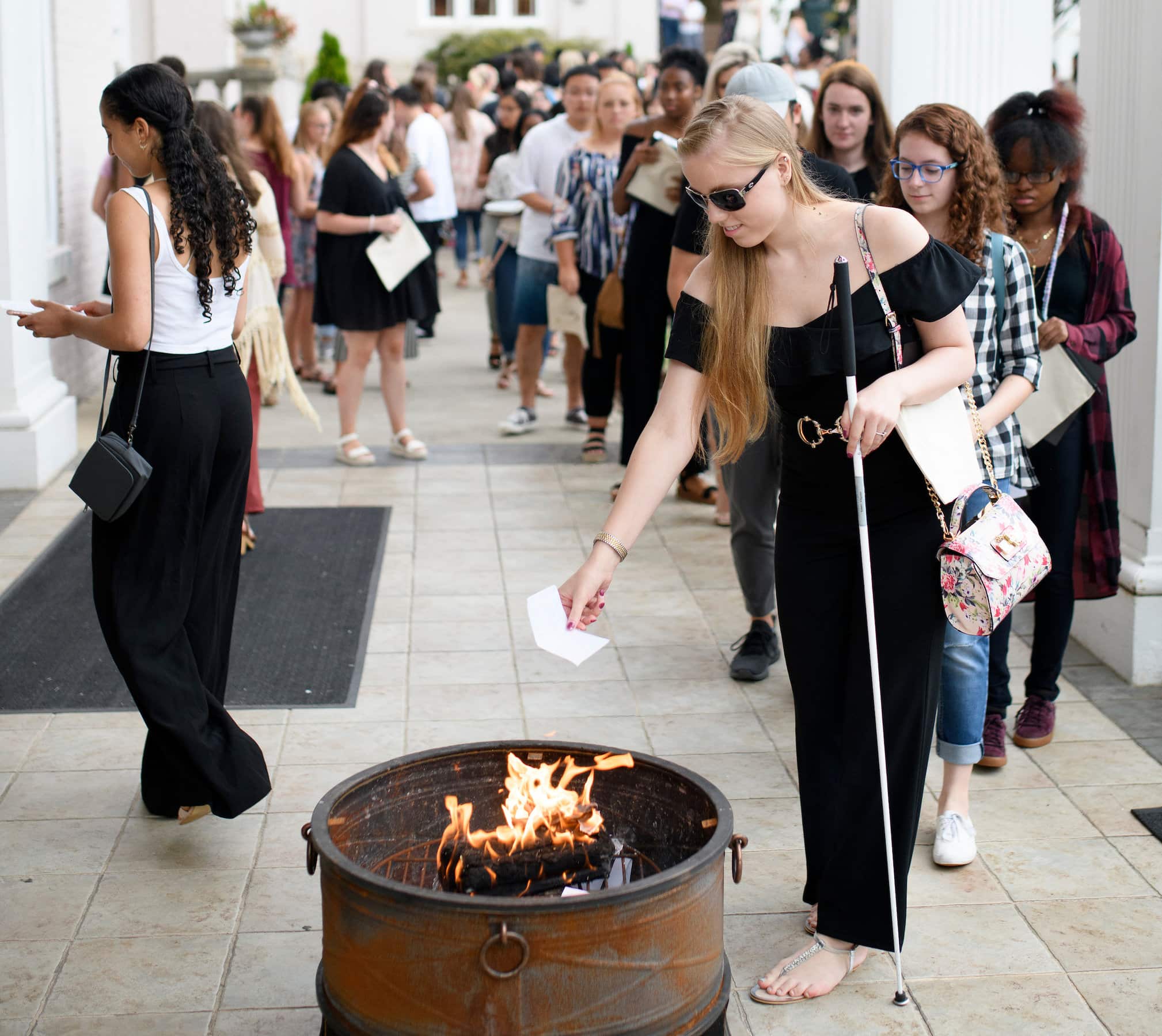 student drops paper into the fire