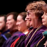 Profile view of faculty on stage.