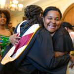 Students hug in lobby of Pearce Auditorium