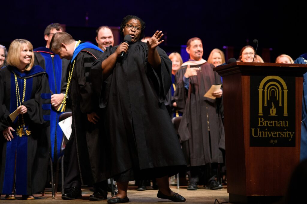 faculty member singing on stage