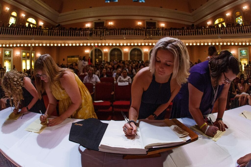 multiple student signing the honor code