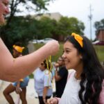 A student receives a gold necklace.