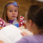 Lillian Kennedy listens to Kelly Peters read the story that she created during LitFest at the Brenau University Downtown Center. (AJ Reynolds/Brenau University)