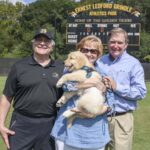 Brenau President Ed Schrader poses for a photo with Kay and Doug Ivester and their 10 week old golden retriever puppy Max at Pacolet Milliken Field at the Ernest Ledford Grindle Athletics Park on Saturday, Sept. 22, 2018. (AJ Reynolds/Brenau University)