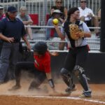 Catcher holding the ball while player slides into home