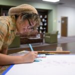 Art student Jennifer Benitez paints a replica of a print from the Arader collection