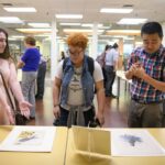 Students and faculty view works from the Arader Art Fund on display in the Brenau Trustee Library.