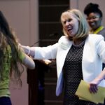 Debra Dobkins hands a student a prize at the speaker series.