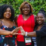 three people making a triangle with their hands