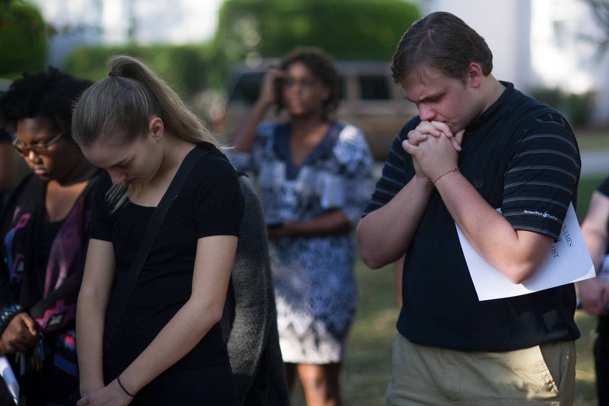 Kyle Gomez-Leineweber prays during the Vigil for Lives Lost. (AJ Reynolds/Brenau University)