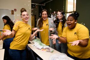 Four Brenau students throw confetti