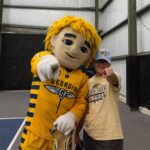 A student poses with a mascot at National Fitness Day.