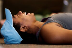 Zafyre Sexton laughs while laying on the ground doing yoga