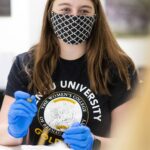 student looks up from making a GOLDen gram
