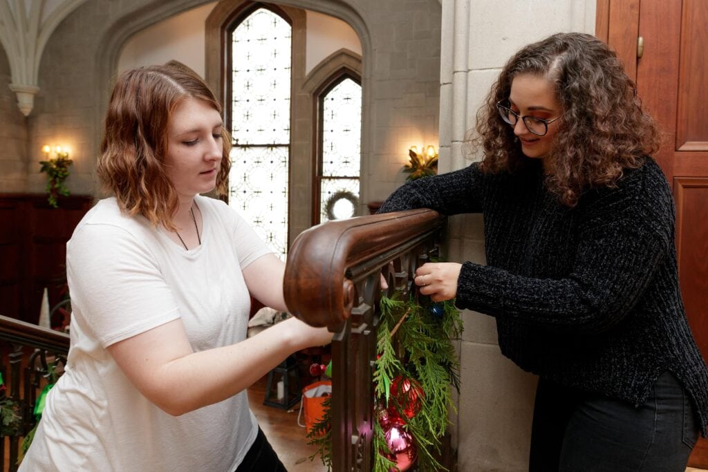 Karen Baker and Dominique Wagner work on decorating the grand staircase at the Callanwolde Fine Arts Center in Atlanta on Tuesday, Nov. 20, 2018. (AJ Reynolds/Brenau University)