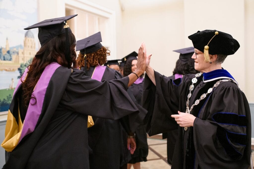 Students give a high five to the president as they walk by