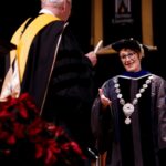 president looks at student on stage