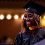 Student smiles as she receives diploma